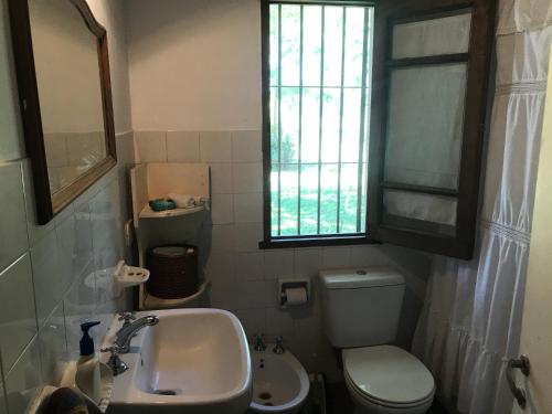 a bathroom with a sink and a toilet and a window at Baradero - La vida de campo a una hora del Obelisco! km142 R9 - las chapas casa de campo baradero in Baradero