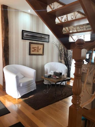 a living room with two white chairs and a table at A Esmorga-Posada del Mar in Vilagarcia de Arousa