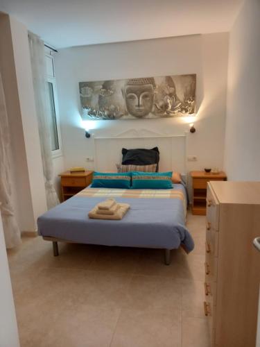 - une chambre dotée d'un lit avec un masque mural dans l'établissement Apartamento en la costa brava, à Palafrugell
