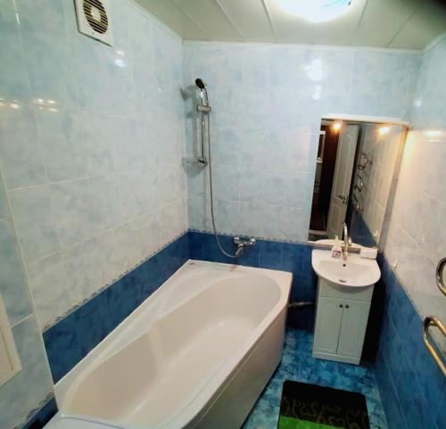 a bathroom with a white tub and a sink at Апартаменты Харьковская in Sumy