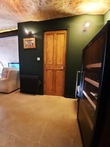 a living room with a wooden door and a couch at Mas" La Maison de mon Père " Proche AVIGNON à PUJAUT in Pujaut