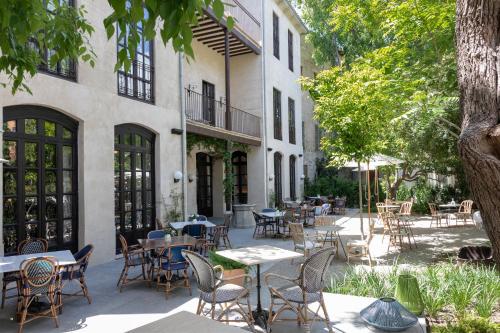 an outdoor patio with tables and chairs and trees at Can Bordoy Grand House Hotel GL Preferred Hotel in Palma de Mallorca