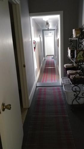 a hallway with a long hallway with a door and a carpet at The Burlington Hotel & Bar - Alma WI in Alma