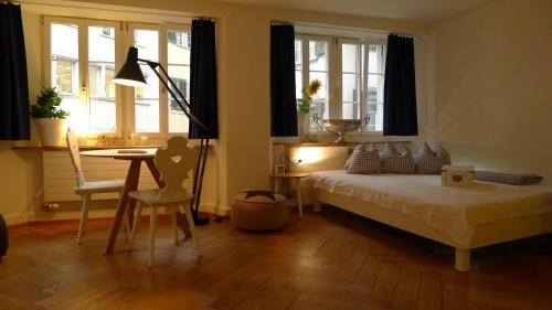 1 dormitorio con cama, mesa y ventanas en Signature Bijou, en Zúrich