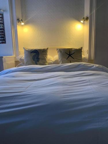 a large white bed with pillows in a bedroom at Ye Olde White Harte Hotel in Burnham on Crouch