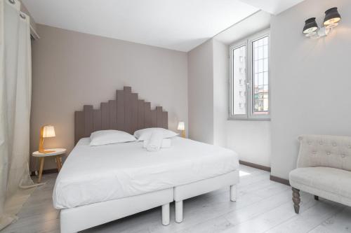 une chambre blanche avec un grand lit et une chaise dans l'établissement Amazing 3 Bdrs and Garden Place du Pin Parking !, à Nice