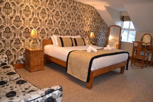 um quarto de hotel com uma cama e uma cadeira em Walsh's Hotel and Apartments em Maghera