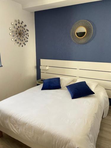 a bedroom with a large white bed with blue pillows at Sarl Macarena in Pouillenay