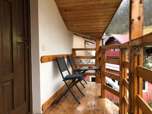ein Balkon mit zwei Stühlen auf einer Holzterrasse in der Unterkunft Toni Room in Sighişoara