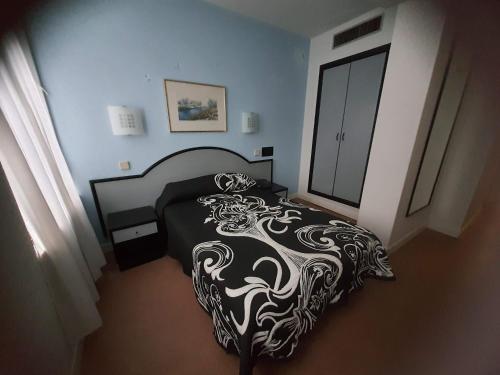 a bedroom with a bed with a black and white comforter at Hotel Arha Santander in Santander
