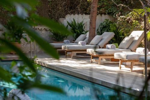 a row of lounge chairs next to a swimming pool at Can Bordoy Grand House Hotel GL Preferred Hotel in Palma de Mallorca