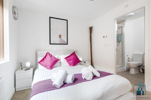 sypialnia z dużym białym łóżkiem z różowymi poduszkami w obiekcie City View Apartments B5 Central City Centre w Birmingham