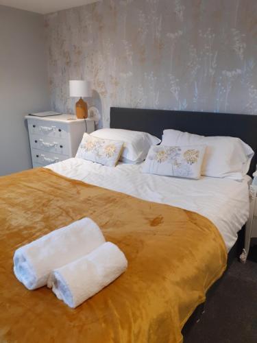 a bedroom with a large bed with towels on it at Crossroads House in Carlisle