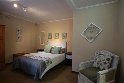 a bedroom with a bed and a chair at Big Tree Midrand in Midrand