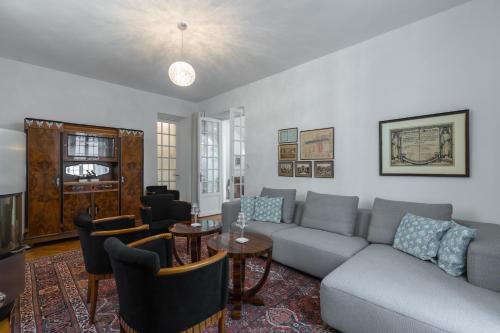 ein Wohnzimmer mit einem Sofa, einem Tisch und Stühlen in der Unterkunft Stylish Art Deco villa near the sea 4 Bdrs Pool and garage in Nizza