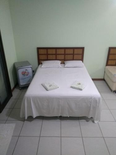 a bedroom with a white bed with two towels on it at Paraíso do sul - Carmery in Pontal do Paraná