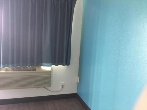 a room with a window with a radiator and a curtain at Motel 6-Baker City, OR in Baker City