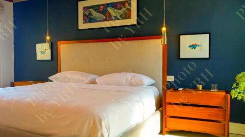 a bedroom with a white bed and a blue wall at Esciros in Chicxulub
