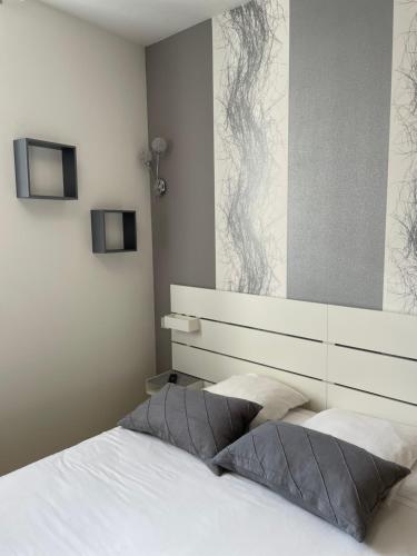 a bedroom with a white bed with a headboard at Sarl Macarena in Pouillenay