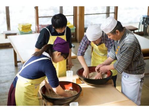 um grupo de pessoas em uma cozinha preparando comida em Daichan Farm Guest House - Vacation STAY 19124v 