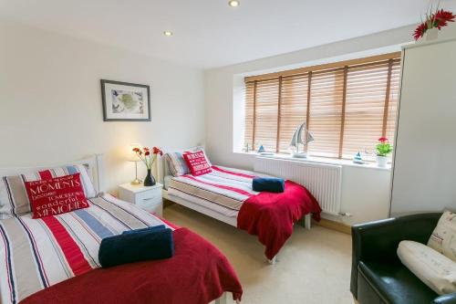 1 dormitorio con 2 camas, sofá y ventana en Bwthyn Bach en Llanrhyddlad