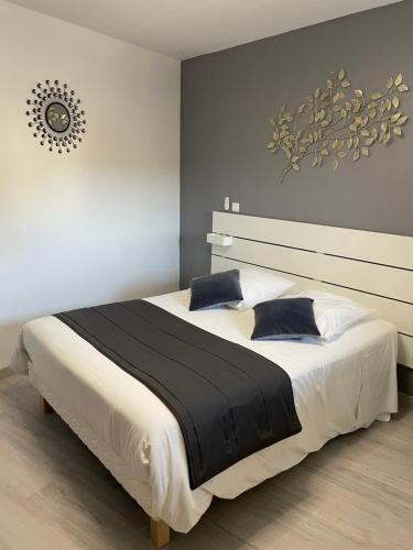a bedroom with a large white bed with blue pillows at Sarl Macarena in Pouillenay