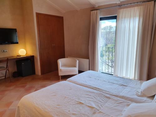 Un dormitorio con una cama grande y una ventana en Hotel Rural Casa Pernías en Moratalla