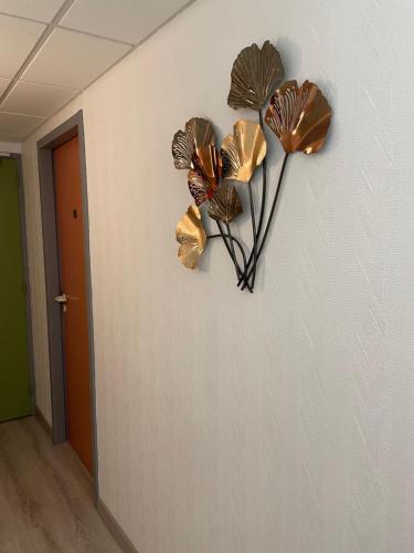 a wall with three bronze flowers on a wall at Sarl Macarena in Pouillenay
