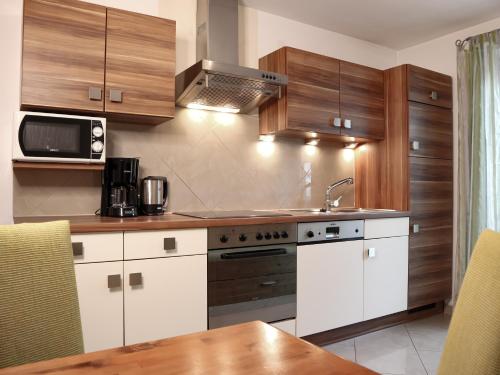 a kitchen with white cabinets and a stove top oven at Appartement Sonnenschein in Neustift im Stubaital