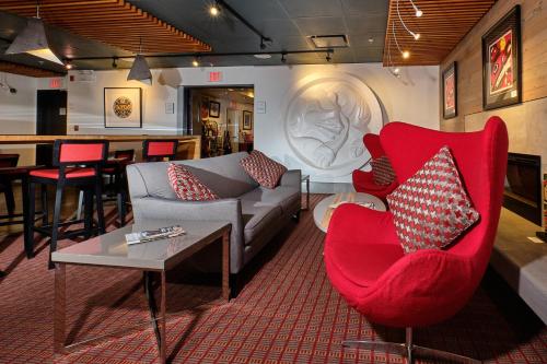 a living room with a red chair and a couch at Skwachàys Lodge in Vancouver