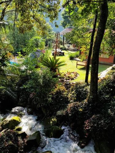 a stream in a garden next to a park at Tékinfin, você chegou! Lindo sítio em Secretário! in Petrópolis