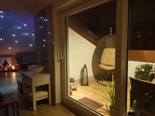 a reflection of a room with a swing in a window at Wellness Apartmány EMPORIO in Loštice