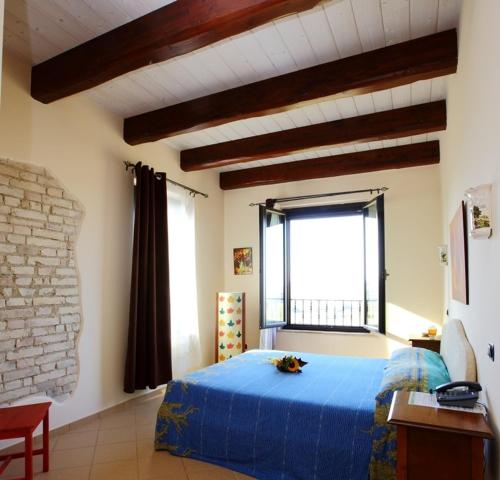 a bedroom with a blue bed and a large window at Il Casale Dei Ciliegi in SantʼOmero
