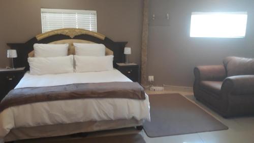 a bedroom with a bed and a couch and a chair at Robertsham (Halaal) Self Catering Cottages 2 in Johannesburg