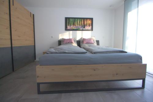 a bedroom with a large bed with a wooden frame at Ferienwohnung Hegaublüte in Engen