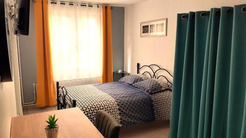 - une chambre avec un lit, une table et une fenêtre dans l'établissement Charmant studio en plein centre avec parking, à Saint-Omer