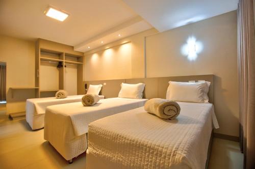 a hotel room with two beds with towels on them at Novares Hotel in Goiânia