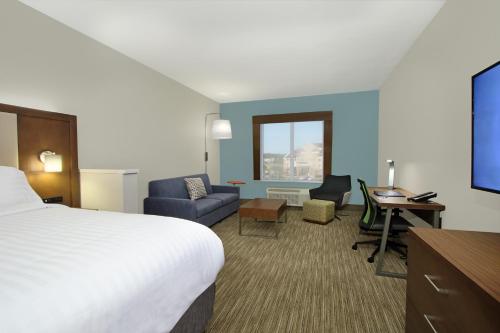 a hotel room with a bed and a desk and chair at Holiday Inn Express & Suites Columbus North by IHG in Columbus