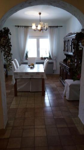 a dining room with a table and white chairs at Villa Drenje in Ključ Brdovečki