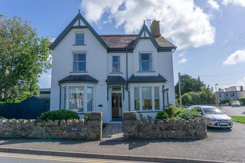 a white house with a car parked in front of it at The Wylfa in Abersoch