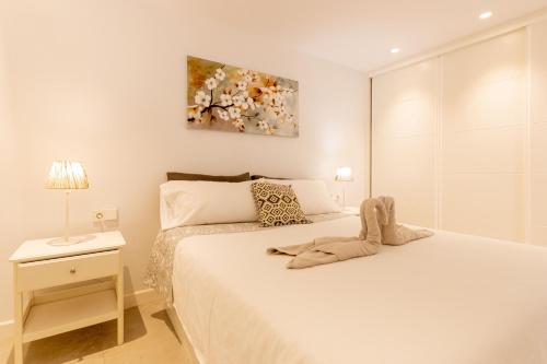 Habitación blanca con cama y mesita de noche en NEPTUNO 1A019 en Puerto de Santiago