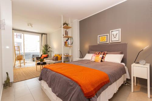 拉斯帕爾馬斯的住宿－Canteras Little Gem，一间卧室配有一张带橙色毯子的大床