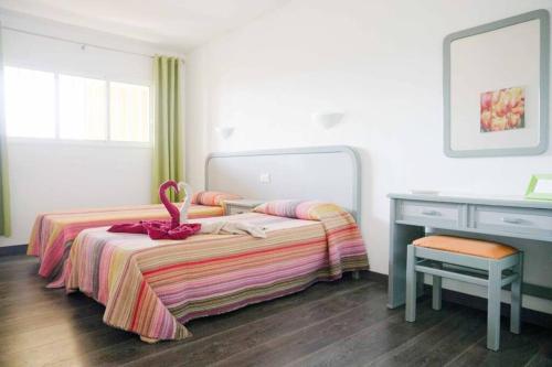 Schlafzimmer mit einem Bett, einer Kommode und einem Schreibtisch in der Unterkunft Primera linea playa, vista espectacular in El Médano