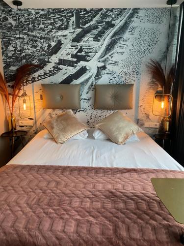 a bedroom with a large bed with two pillows at Palace Hotel Zandvoort in Zandvoort