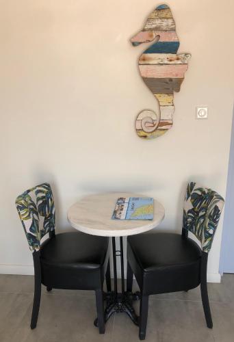 a table with two chairs and a sign on the wall at INDIGO Apartments & Suites - 'Adults Only' in Jan Thiel