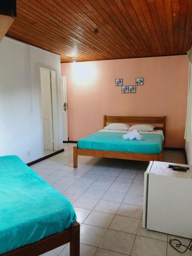 a bedroom with two beds and a wooden ceiling at Anexo Aldeia Búzios in Búzios