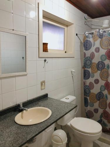 baño con lavabo y aseo y ventana en Anexo Aldeia Búzios, en Búzios
