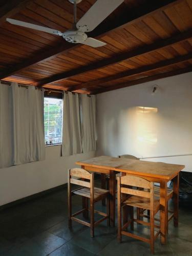 a dining room table with chairs and a ceiling fan at Anexo Aldeia Búzios in Búzios