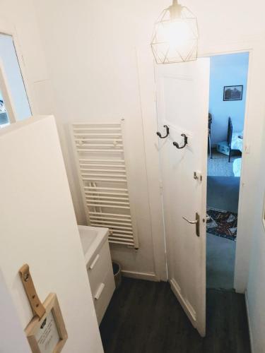 La petite salle de bains est pourvue d'une porte blanche et d'un lavabo. dans l'établissement La maison du Mauret, à Andernos-les-Bains