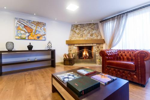 sala de estar con sofá y chimenea en Pousada Itália Moderna, en Campos do Jordão